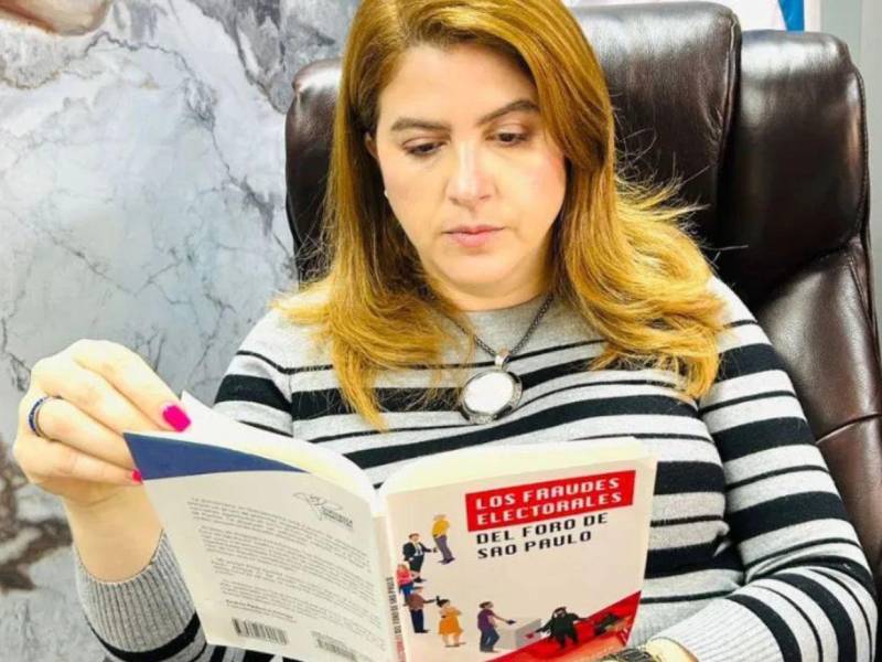 La presidenta del Consejo Nacional Electoral (CNE), Cossette López, leyendo el libro Los fraudes electorales del Foro de Sao Paulo.